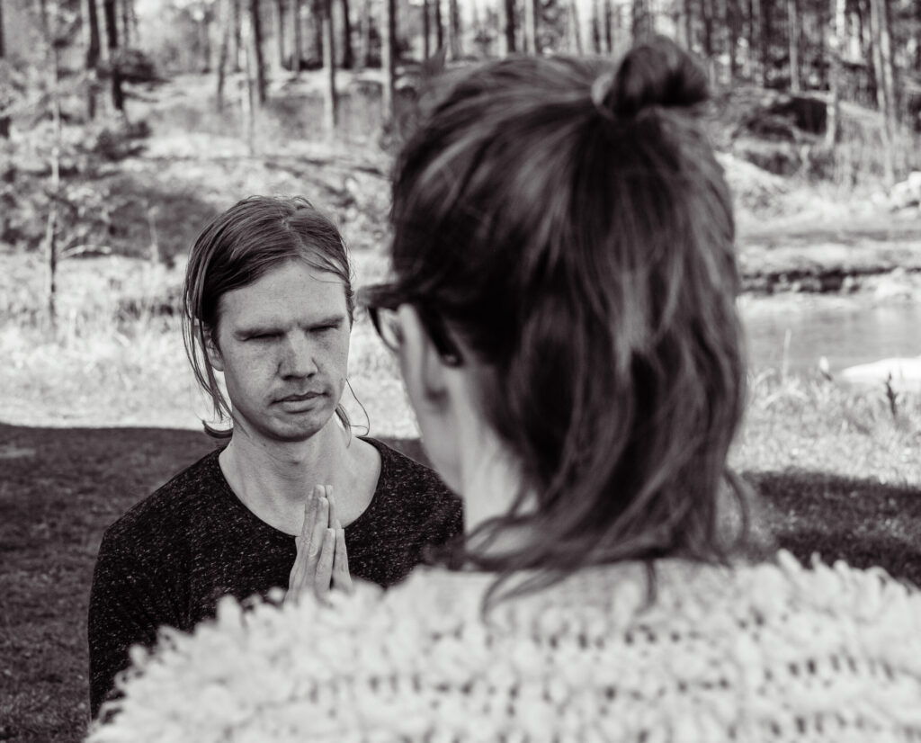 Lars starts a session outside next to female client with forest as background